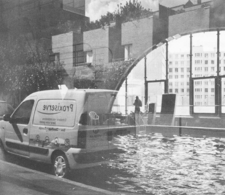 Dans l'eau de la piscine. Par la grande baie qui éclaire le bassin de la piscine rue David d'Angers… un reflet est venu « planter » dans l'eau du bassin… une camionnette et les maisons d'en face… mais ce n'est qu'une illusion d'optique.